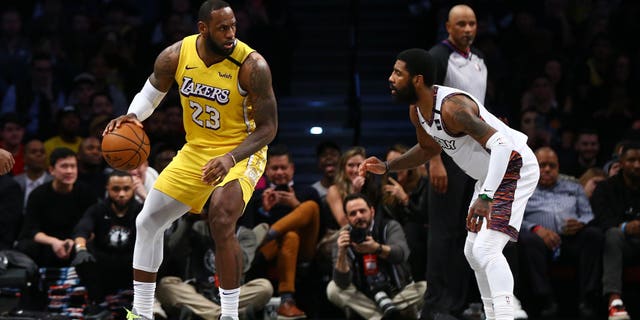 LeBron James #23 of the Los Angeles Lakers drives to the basket against Kyrie Irving #11 of the Brooklyn Nets at Barclays Center on January 23, 2020 in New York City.