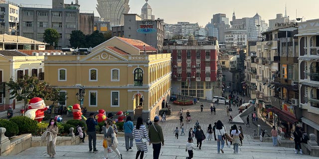 Macao, el centro de juegos de azar más grande del mundo, está relajando su mandato de máscara COVID-19 4 Los turistas caminan en un sitio histórico en Macao el 28 de diciembre de 2022. A partir del 27 de febrero de 2023, las personas ya no tienen que usar máscaras cuando están al aire libre.