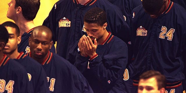El armador de los Denver Nuggets, Mahmoud Abdul-Rauf, ora durante el canto del himno nacional antes de un partido de los Nuggets contra los Chicago Bulls en el United Center de Chicago el 15 de marzo de 1996.