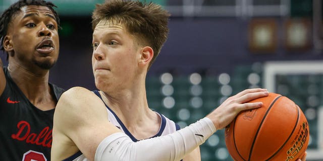 Max Shulga de los Utah State Aggies busca un pase contra los SMU Mustangs durante el Diamond Head Classic de Hawaiian Airlines el 23 de diciembre de 2022 en Honolulu.