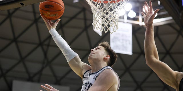 Max Shulga de los Utah State Aggies lanza una bandeja invertida durante el juego del Diamond Head Classic de Hawaiian Airlines contra los Seattle Redhawks en el SimpliFi Arena el 22 de diciembre de 2022 en Honolulu.