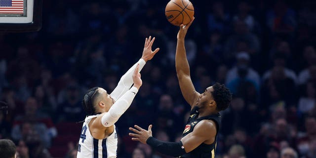 Le garde des Cleveland Cavaliers Donovan Mitchell, à droite, tire contre l'attaquant des Memphis Grizzlies Dillon Brooks lors de la première moitié d'un match de basket de la NBA, le jeudi 2 février 2023, à Cleveland. 