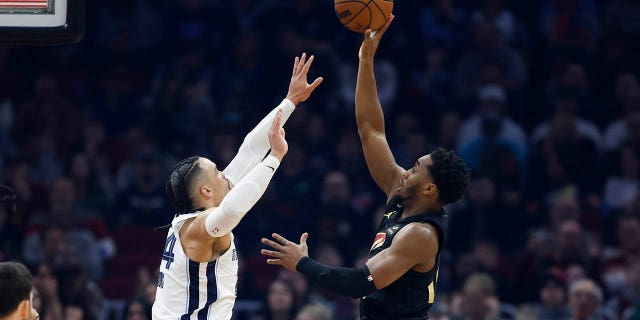 Le garde des Cleveland Cavaliers Donovan Mitchell, à droite, tire contre l'attaquant des Memphis Grizzlies Dillon Brooks lors de la première moitié d'un match de basket de la NBA, le jeudi 2 février 2023, à Cleveland. 