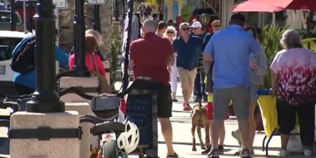 Busy street for tourists and locals in New Smyrna Beach, Florida, as an overnight curfew for juveniles is considered.