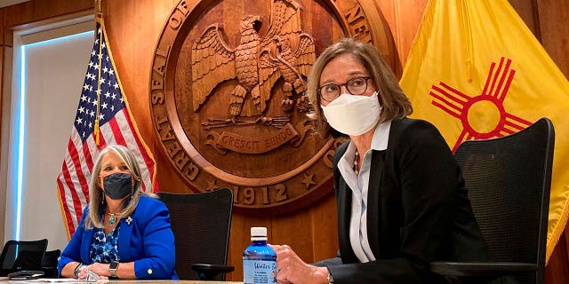 Retired New Mexico Supreme Court Justice Barbara J. Vigil, right, and New Mexico Gov. Michelle Lujan Grisham listen during a news conference in Santa Fe. Lujan Grisham announced Feb. 16, 2023, an overhaul of the state's lead agency for protecting children from neglect and abuse.