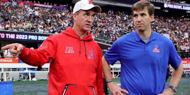 El entrenador en jefe de la NFC, Eli Manning, a la derecha, y el entrenador en jefe de la AFC, Peyton Manning, conversan durante los Juegos de Pro Bowl de la NFL 2023 en el Allegiant Stadium el 5 de febrero de 2023 en Las Vegas.