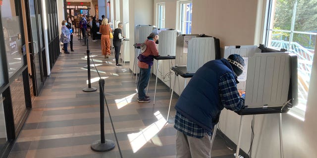 Santa Fe County, New Mexico, residents fill out ballots during the first day of general election voting on Oct. 11, 2022, in a hallway outside the Santa Fe County Clerk's Office.