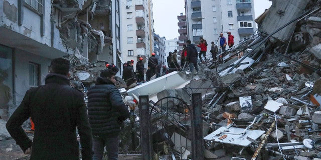 Las personas y los equipos de rescate intentan llegar a los residentes atrapados dentro de los edificios derrumbados en Adana, Turquía, el lunes 6 de febrero de 2023. Un poderoso terremoto derribó varios edificios en el sureste de Turquía y Siria y se temen muchas víctimas.