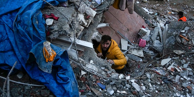 A man searches for people at a destroyed building in Adana, Turkey on Monday, February 6, 2023. A powerful earthquake has knocked down several buildings in southeast Turkey and Syria and many casualties are feared.