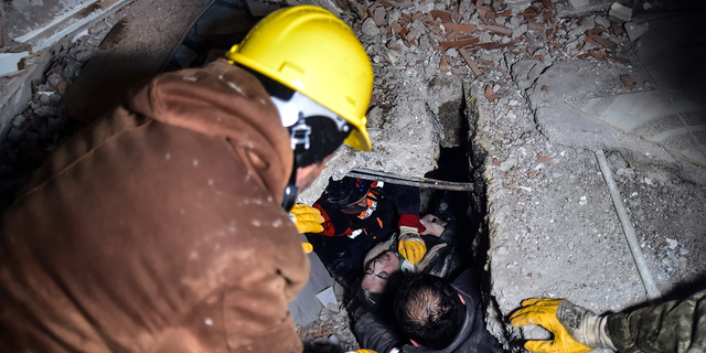 Emergency workers and medics rescue a woman out of the debris of a collapsed building in Elbistan, Kahramanmaras, in southern Turkey, Tuesday, Feb. 7, 2023.