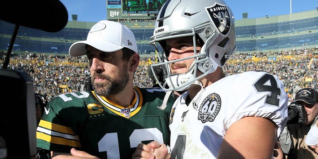 Aaron Rodgers and Derek Carr of the Oakland Raiders meet after the Packers' 42-24 win at Lambeau Field on Oct. 20, 2019, in Green Bay, Wisconsin.