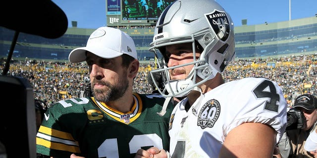 Aaron Rodgers, #12 of the Green Bay Packers, and Derek Carr, #4 of the Oakland Raiders, meet after the Packers beat the Raiders 42-24 at Lambeau Field on October 20, 2019, in Green Bay, Wisconsin.