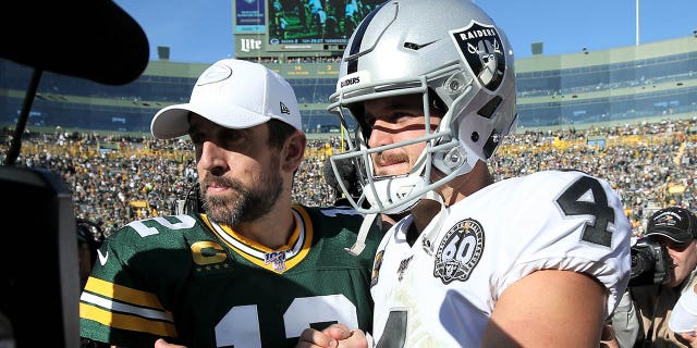 Aaron Rodgers y Derek Carr de los Oakland Raiders se encuentran después de la victoria de los Packers por 42-24 en Lambeau Field el 20 de octubre de 2019 en Green Bay, Wisconsin.