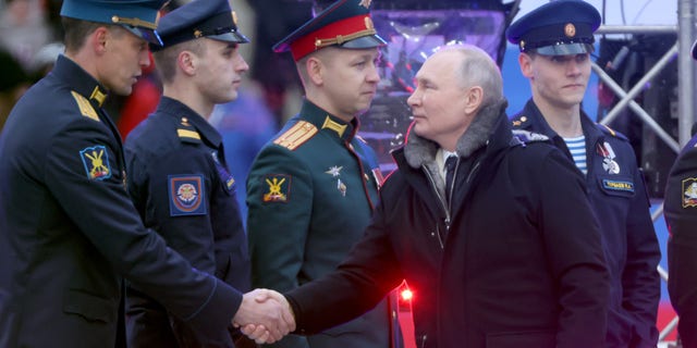 El presidente Vladimir Putin saluda a miembros del ejército durante un concierto en el estadio Luzhniki el 22 de febrero de 2023 en Moscú, el mismo día que anunció la suspensión de la participación de Rusia en el tratado New START.