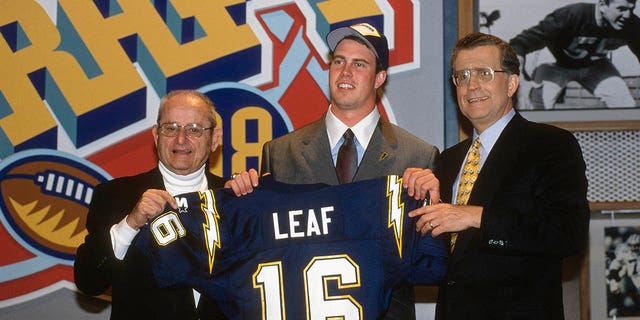 La selección de primera ronda de los San Diego Chargers, Ryan Leaf (centro), posa para esta foto con el propietario Alex Spanos, a la izquierda, y el comisionado de la NFL, Paul Tagliabue, durante el Draft de la NFL el 18 de abril de 1998 en el Theatre at MSG en el distrito neoyorquino de Manhattan. .  York.