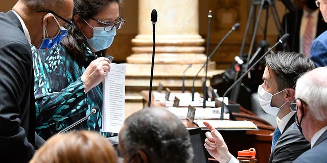 Kentucky state Sen. Karen Berg, left, speaks with Sen. Morgan McGarvey during the last day of the state session at the state Capitol in Frankfort on March 30, 2021. 