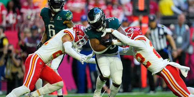 Philadelphia Eagles running back Boston Scott, #35, is tackled by Kansas City Chiefs cornerback Trent McDuffie, #21, and safety Juan Thornhill, #22, during the first half of Super Bowl LVII, Sunday, Feb. 12, 2023, in Glendale, Arizona.