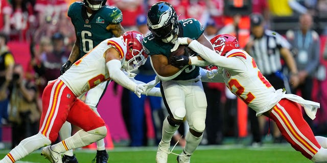 El corredor de los Philadelphia Eagles, Boston Scott (35), es abordado por el esquinero de los Kansas City Chiefs, Trent McDuffie (21) y el profundo Juan Thornhill (22), durante la primera mitad del Super Bowl LVII, el domingo 12 de febrero de 2023, en Glendale, Arizona. 