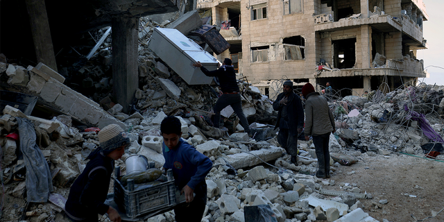 People remove furniture and appliances from a collapsed building after a devastating earthquake rocked Syria and Turkey in the city of Jinderis, Syria February 7, 2023.