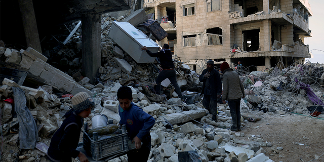 People remove furniture and appliances from a collapsed building after a devastating earthquake rocked Syria and Turkey in the city of Jinderis, Syria February 7, 2023.