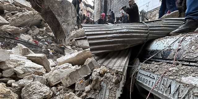 Petugas Pertahanan Sipil Suriah dan pasukan keamanan mencari puing-puing bangunan yang runtuh, di Aleppo, Suriah, Senin, 6 Februari 2023.