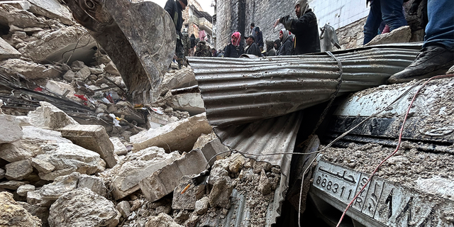 Petugas Pertahanan Sipil Suriah dan pasukan keamanan mencari puing-puing bangunan yang runtuh, di Aleppo, Suriah, Senin, 6 Februari 2023.