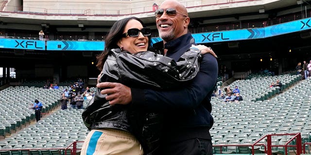 XFL owners Dwayne Johnson and Dany Garcia greet each other on the field before the game between the Arlington Renegades and the Vegas Vipers at Choctaw Stadium on February 18, 2023, in Arlington, Texas.