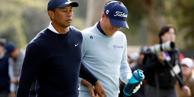 Tiger Woods of the United States (L) and Justin Thomas of the United States tee off the 9th tee during the first round of the Genesis Invitational at the Riviera Country Club on February 16, 2023 in Pacific Palisades, California. 