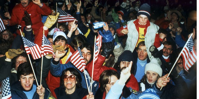 U.S. ice hockey fans wave national flags as they celebrate the United States' upset victory over the Soviet Union (4-3) in the Olympic semifinal match on Feb. 22, 1980, in Lake Placid at the Winter Olympic Games. The USA advanced to the final, where they played Finland for the gold medal. 