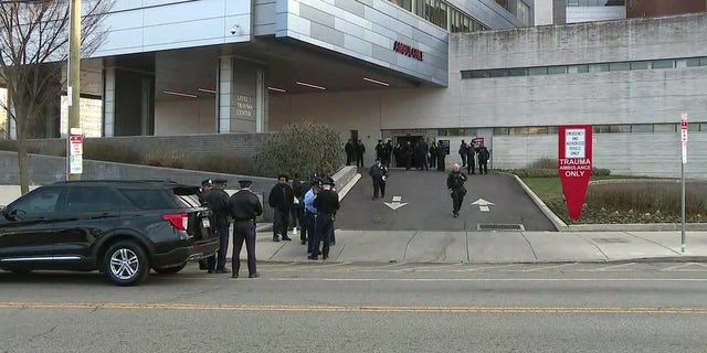 Philadelphia police officers gather outside a hospital where a fellow officer was taken after being shot. 