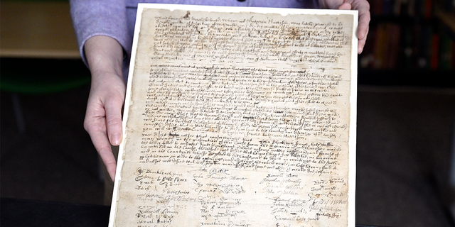 La asociada de colecciones de la Sociedad Histórica de Connecticut, Julia Morrow, muestra una carta de queja original que data de 1669 contra Katherine Harrison, el martes 31 de enero de 2023, en Hartford, Connecticut. Harrison, de Wethersfield, Connecticut, fue juzgado varias veces por brujería.