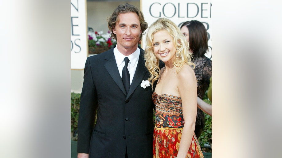 Matthew McConaughey in a black suit and tie for the Golden Globes in 2003 alongside Kate Hudson in a patterned brown, orange, and red dress
