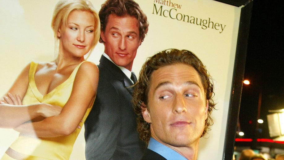 Matthew McConaughey stands in front of "How to Lose a Guy in 10 Days" poster