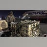 A man in military gear unloads a plane.