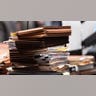 A stack of paperwork sits on a desk inside a courtroom.