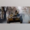 A member of the Russian military rides on a tank.