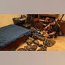 A man lays military gear on his bedroom floor.