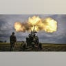 A group of soldiers fire a weapon.