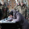 Family, friends and soldiers grieve at the casket of Ukrainian soldier Sergiy Sochenko at his funeral at an Orthodox church on January 28, 2023 outside Rohoziv, Ukraine. The forty-eight-year-old soldier was killed in fighting in the Donetsk district and leaves behind a wife and child. Across the country there are now almost daily funerals for soldiers as the Russian invasion of Ukraine nears its one-year anniversary.  