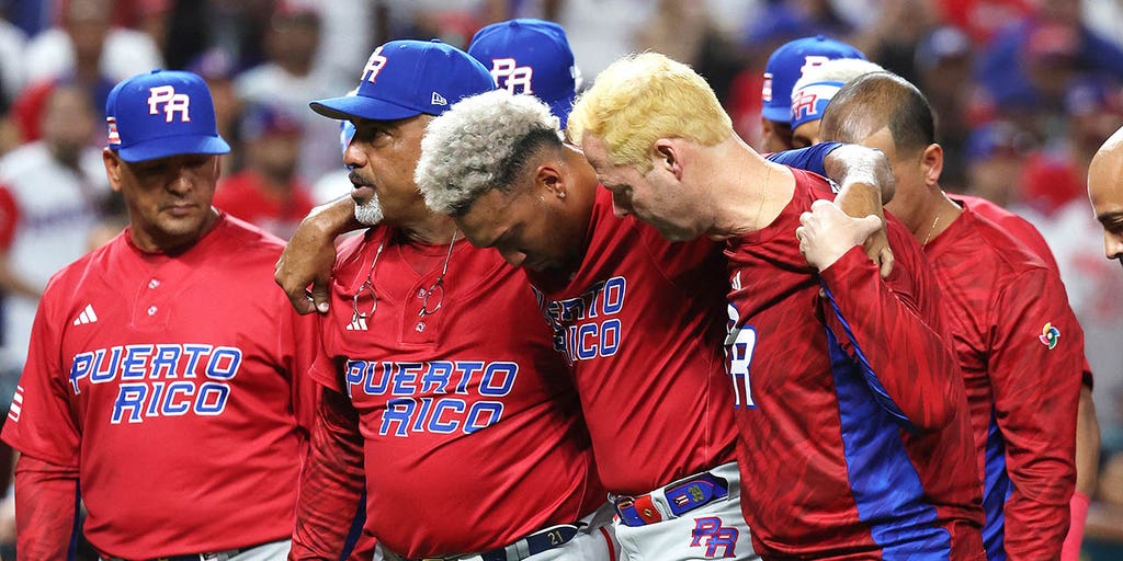 Puerto Rico pitcher Edwin Diaz (39) is being helped by team pitching coach  Ricky Bones and medical staff after the the Pool D game against Dominican  Republic at the World Baseball Classic