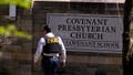 A police officer walks by an entrance to The Covenant School after a shooting in Nashville, Tennessee, on Monday, March 27, 2023.