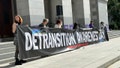 Participants in the "Detransition Awareness Day" rally in Sacramento  hold up a banner advocating for detransitioners. - Fox News