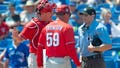 Philadelphia Phillies catcher J.T. Realmuto and manager Rob Thomson argue with umpire Randy Rosenberg after Realmuto was ejected from a spring training baseball game in Dunedin, Fla., Monday, March 27, 2023.