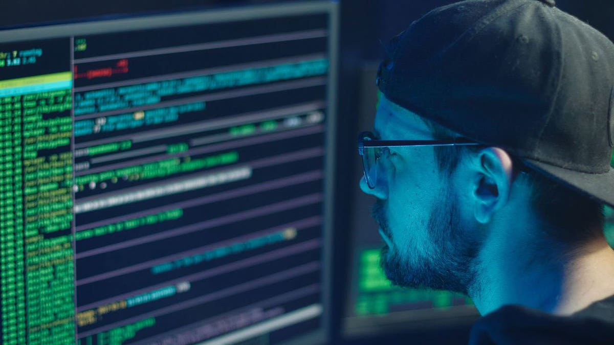 Man staring at his computer screen looking at code.