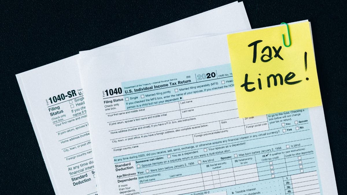 Tax forms with a post-it note that says "Tax Time!"