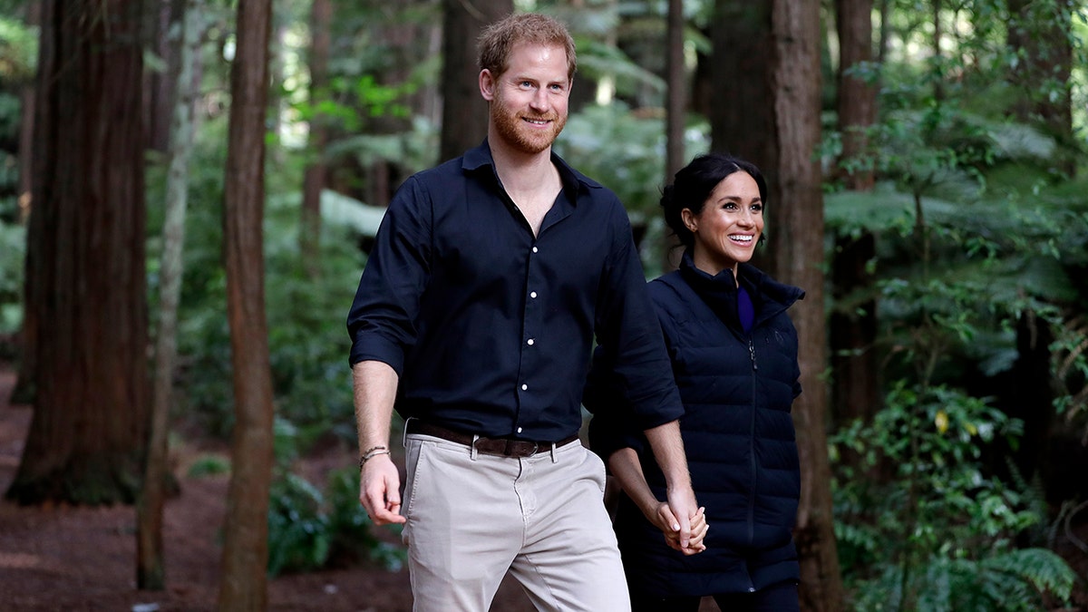 Prince Harry and Meghan Markle walking while holding hands in New Zealand