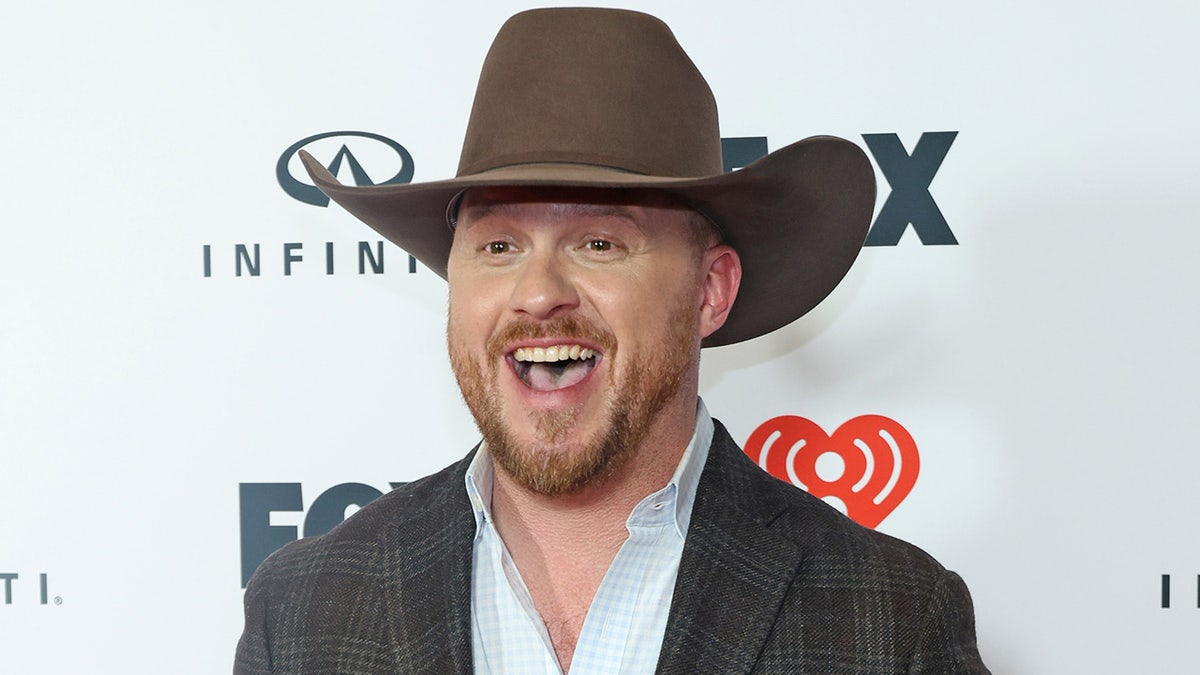 Cody Johnson smiling wide and wearing a cowboy hat