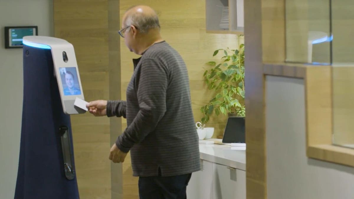 Man scanning his badge with a robot.