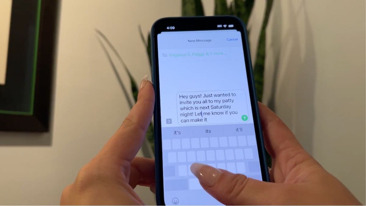 Person holds their phone and types out message on iPhone