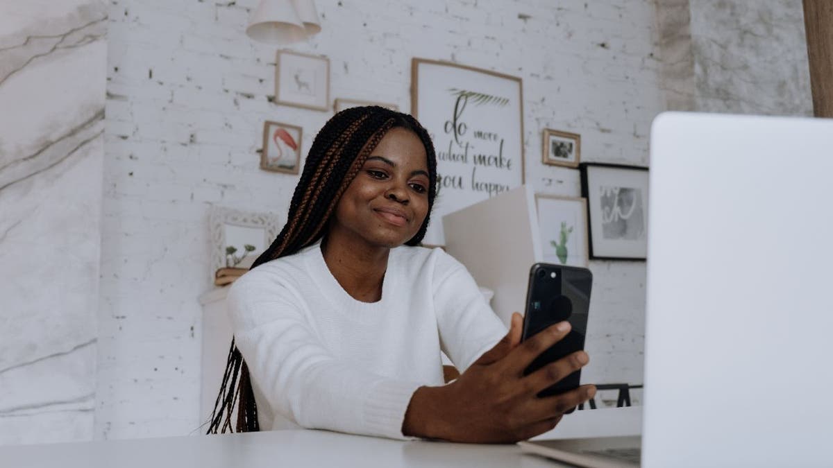 Woman staring into her iPhone.